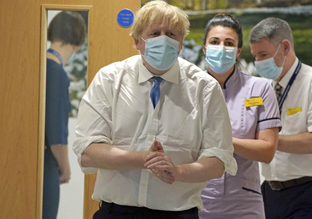 Prime Minister Boris Johnson, center, arrives to visit to the Northern Centre for Cancer Care, North Cumbria, in Carlisle, as part of his tour of Britain, Monday Feb. 14, 2022. (AP)