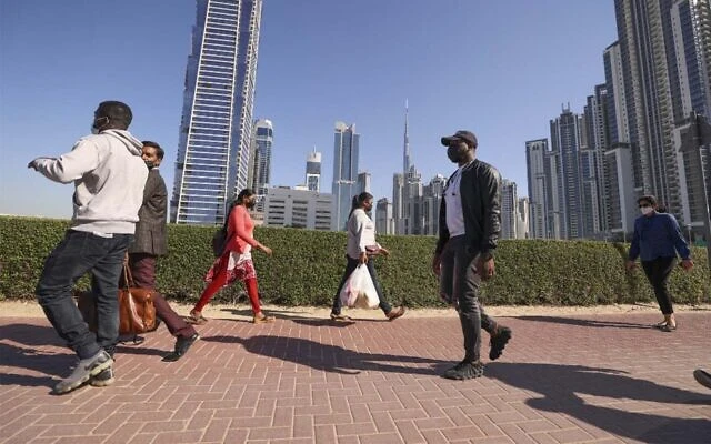 People walk to work in the Gulf Emirate of Dubai, on January 7, 2022. (Karim Sahib/AFP)