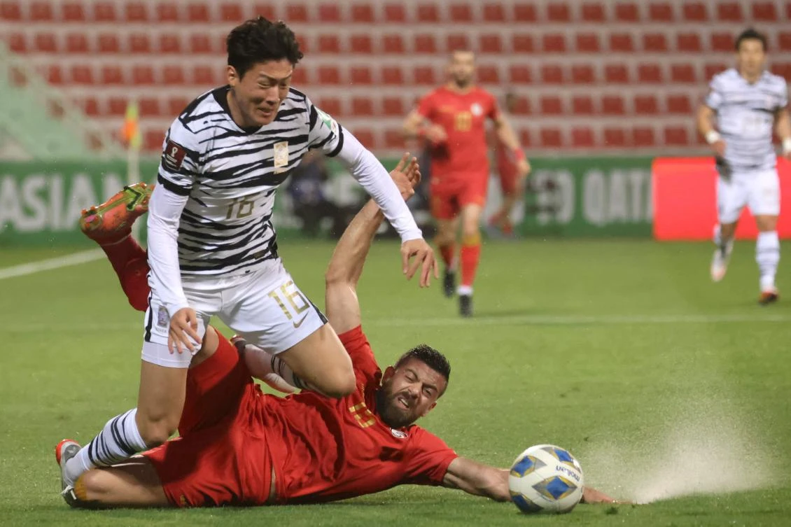 South Korea’s Hwang Ui-jo is marked by Syria’s defender Mohamed Sahyouni during their 2022 Qatar World Cup Asian Qualifiers match between Syria and South Korea, at Rashid stadium in Dubai, on Tuesday. (AFP)