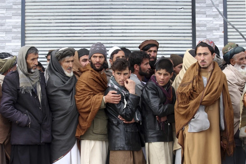 Afghans wait to receive food rations organized by the World Food Program (AP)