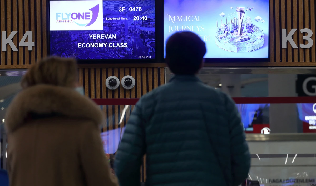 Passengers wait to check-in at the FlyOne Armenia counter for a flight from Istanbul to Yerevan at the Istanbul International Airport in Istanbul, Turkey February 2, 2022. (Reuters)