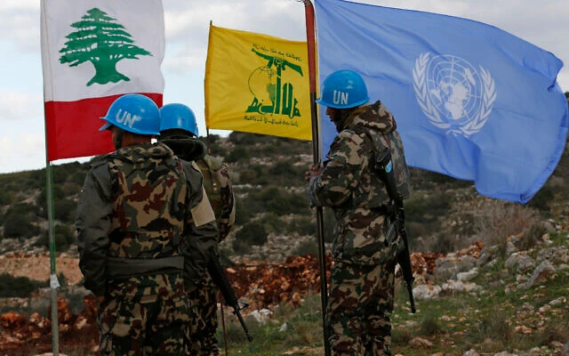 UN peacekeepers hold their flag while standing next to Hezbollah and Lebanese flags. (AP/File Photo)