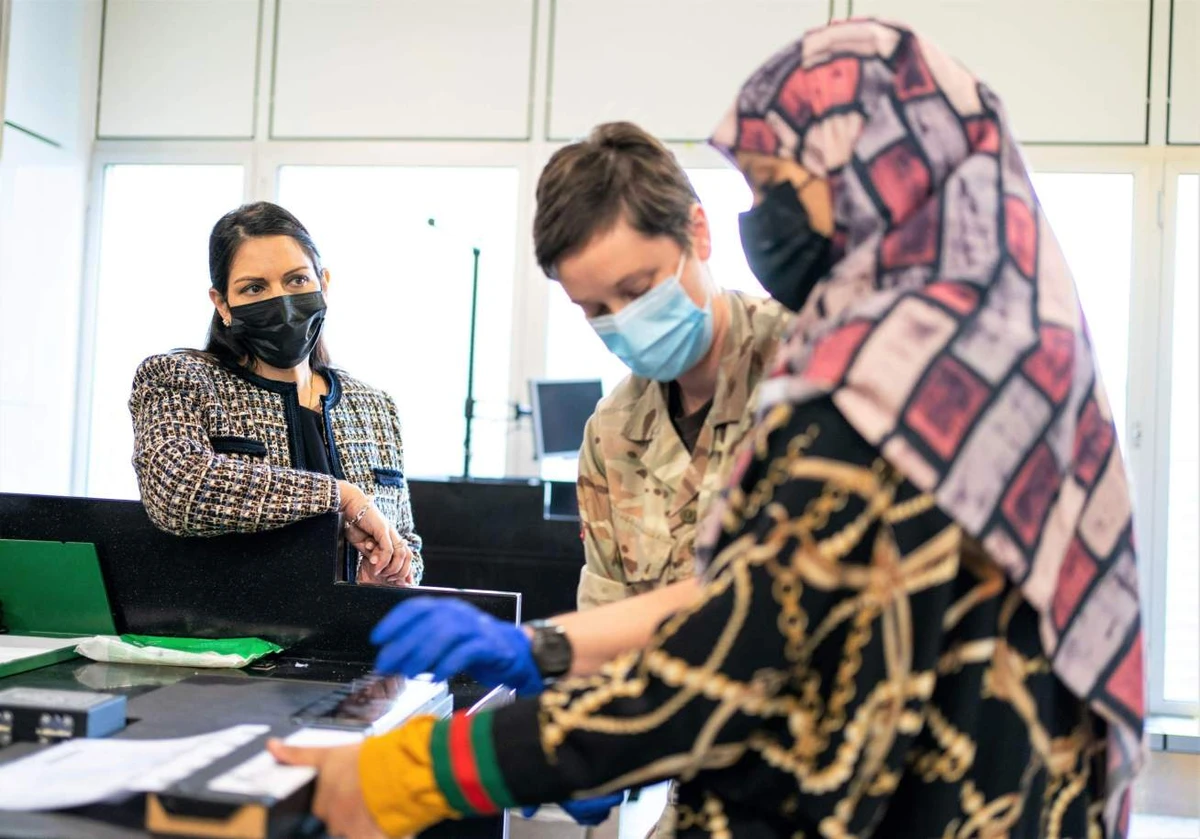 Home Secretary Priti Patel watches as a refugee has her fingerprints taken after arriving from Afghanistan on a evacuation flight at Heathrow Airport. (Reuters/File Photo)