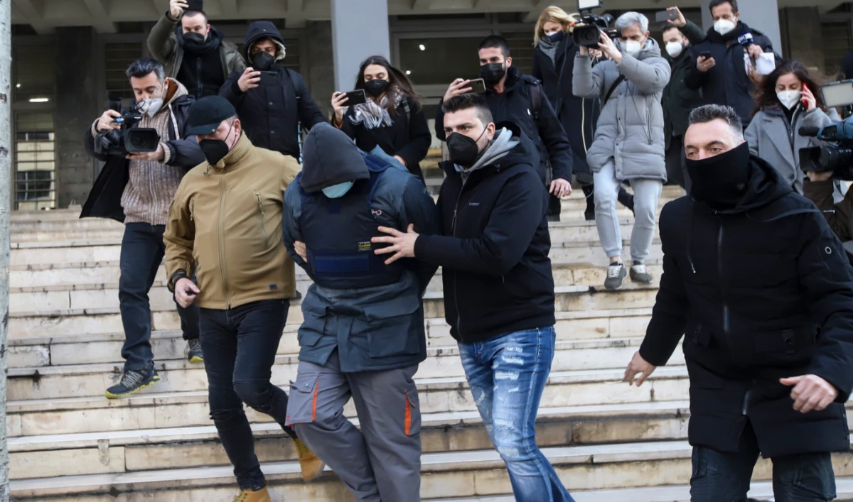 Greek police officers in plain clothes escort the 23 year-old man accused of the murder of 19-year-old city resident Alkis Kambanos as they leave the court house in Thessaloniki Greece, on Thursday Feb. 3, 2022. (AP)
