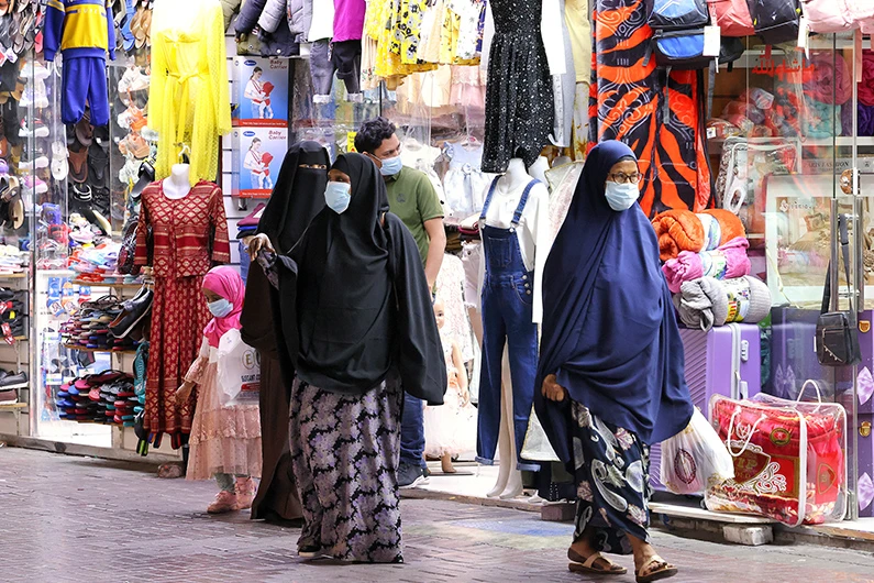 Shoppers walk outside stores in Dubai on May 5, 2021. (AFP/FILE)