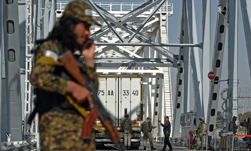 A Taliban border guard stands by as Uzbek border guards check a truck at the Afghanistan-Uzbekistan Friendship Bridge in Hairatan, Afghanistan, Oct 27, 2021. (AFP)