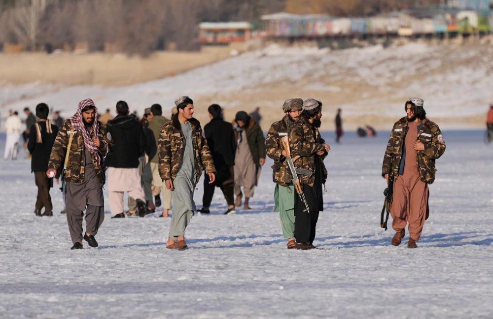 Taliban fighters walk at the frozen Qargha Lake, near Kabul, Afghanistan, in Kabul, Afghanistan, Friday, Feb. 11, 2022. (AP)