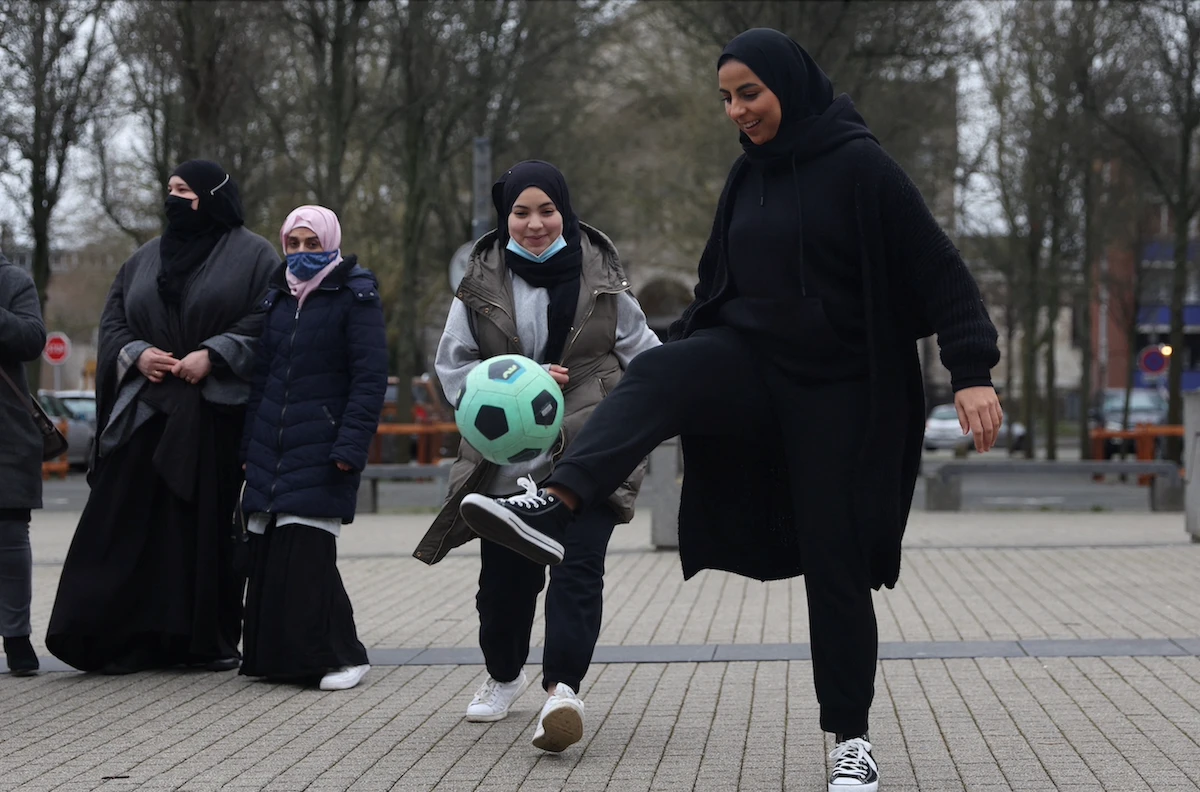 Supporters of the women soccer team “Les Hijabeuses” play soccer in front of the city hall in Lille as part of a protest on February 16, 2022. (Reuters)