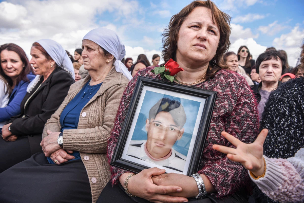 A Kosovo woman holds a picture of her son who went missing during the Kosovo war, during a ceremony on April 5, 2017 marking the 18th anniversary of the massacre in the village of Rezalle. (AFP)