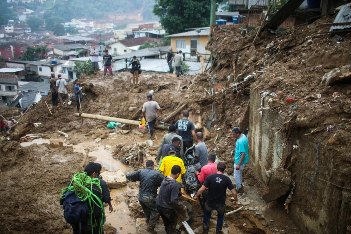 Rescuers carry a body at a mudslide at Morro da Oficina after pouring rains in Petropolis, Brazil, on Feb. 16, 2022. (REUTERS/Ricardo Moraes)