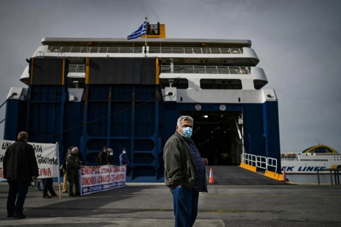 Dock workers gather outside a docked ferry in the port of Piraeus, near Athens. (File/AFP)