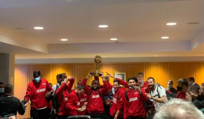 Lebanese basketball team players, who won the Arab Basketball Championship for the first time, at Beirut airport happily showing off their hard-won trophy. (File/NNA)