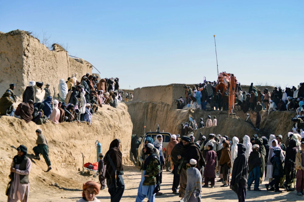 Afghan people gather as rescuers try to reach and rescue a boy trapped for two days down a well in a remote southern Afghan village of Shokak, in Zabul province on Friday. (AFP)
