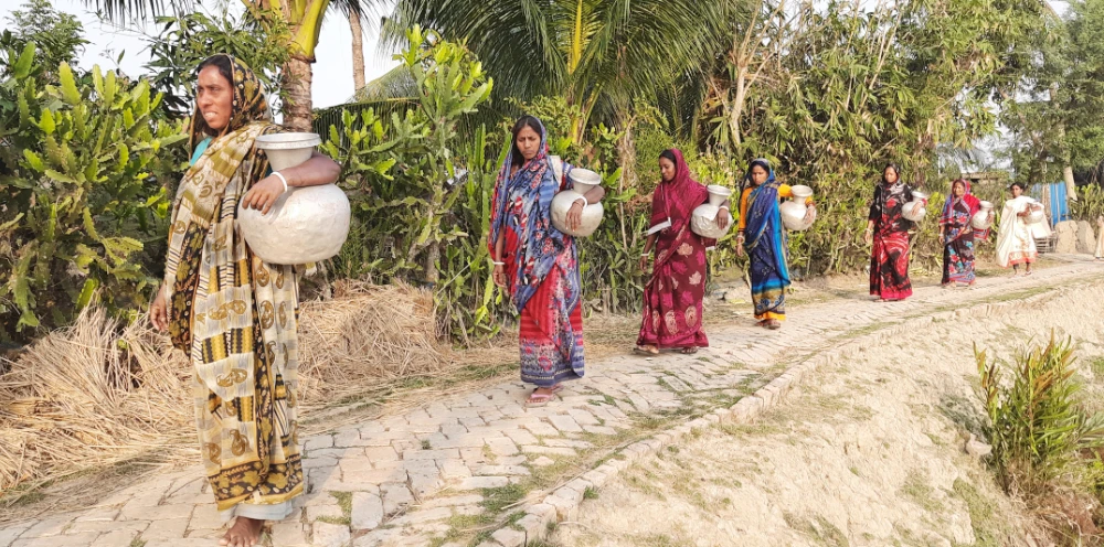 Women carry aluminum pot to fetch safe drinking water for their families in Gabura, an area comprising 15 villages in southern Bangladesh, on Feb. 18, 2022. (Photo courtesy of LEDARS Bangladesh)
