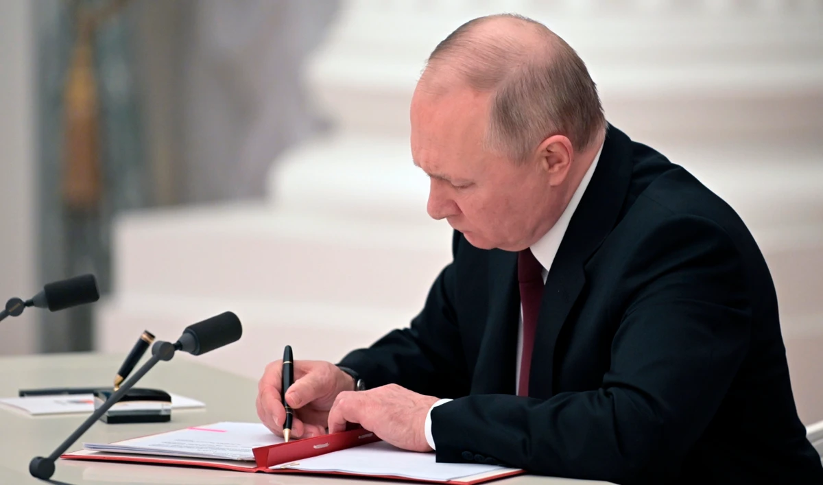 Russian President Vladimir Putin signs a document recognizing the independence of separatist regions in eastern Ukraine in the Kremlin in Moscow, Russia, Monday, Feb. 21, 2022. (AP)