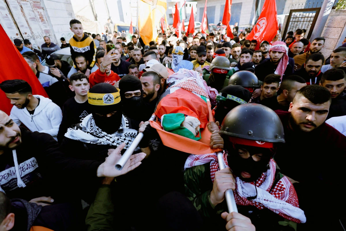 People carry the body of Palestinian boy Mohammed Shehadeh, who was killed by Israeli troops, during his funeral in Bethlehem on Feb. 23, 2022. (REUTERS/Mussa Qawasma)