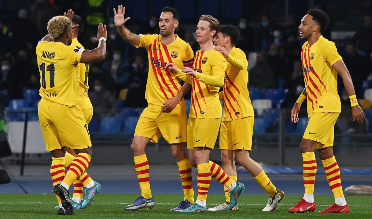 Barcelona's Dutch midfielder Frenkie De Jong (C) celebrates with teammates after scoring his team's second goal during the UEFA Europa League knockout round play-off second leg football match between SSC Napoli and FC Barcelona on February 24, 2022. (AFP)