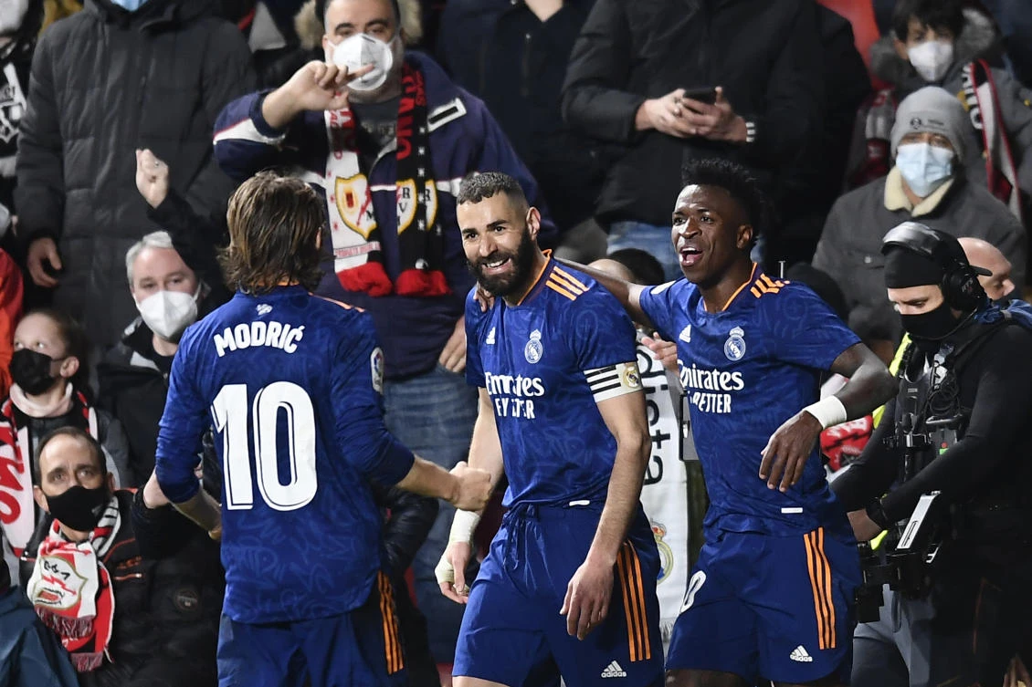 Real Madrid’s Karim Benzema celebrates with Luka Modric and Vinicius Junior after scoring the opening goal during their La Liga match against Rayo Vallecano at the Vallecas stadium in Madrid on Saturday. (AP)