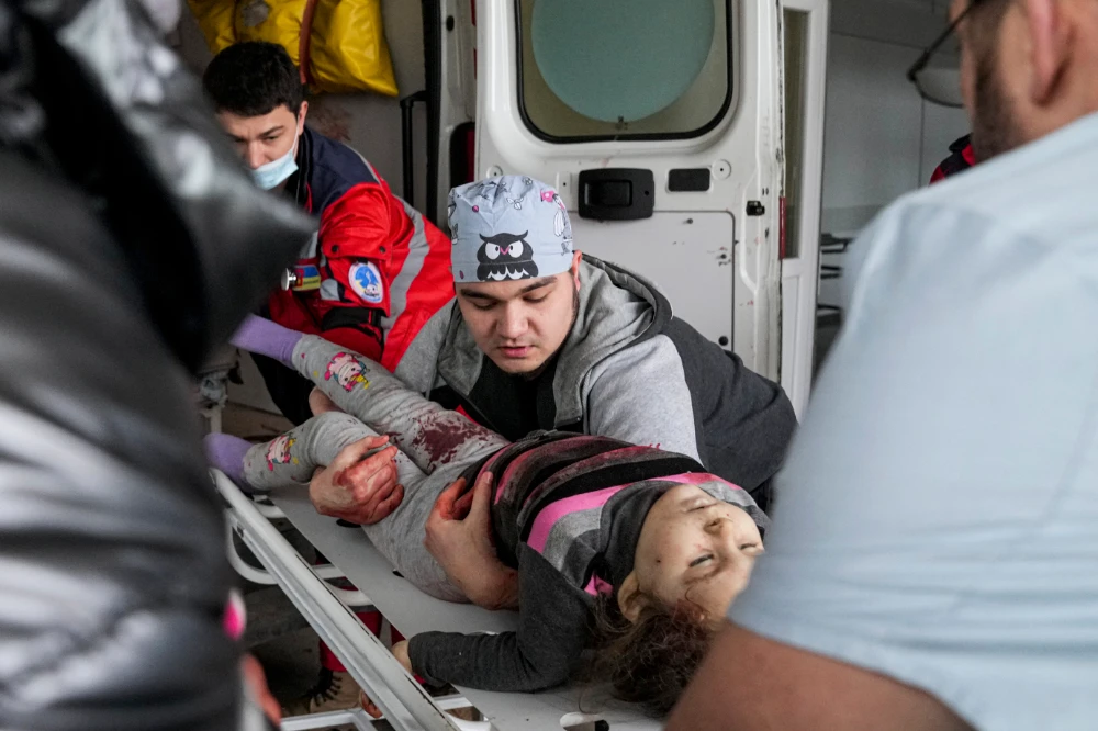 Medics transport a girl injured during shelling from an ambulance in city hospital of Mariupol, eastern Ukraine, Sunday, Feb. 27, 2022. The girl did not survive. (AP)