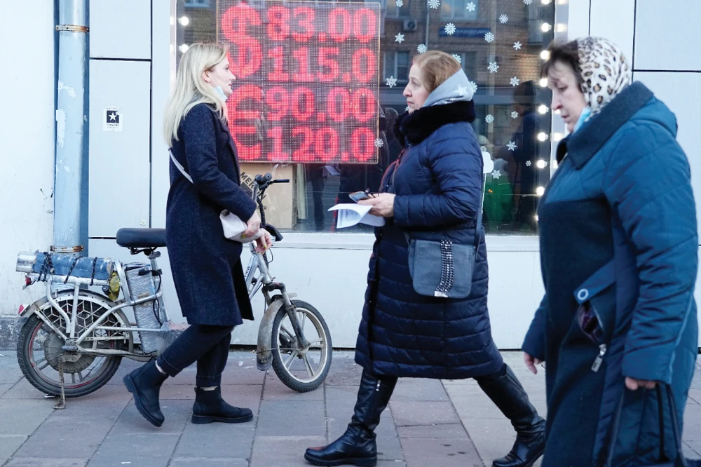 People walk past a currency exchange office screen displaying the exchange rates of US dollar and the euro to Russian rubles in Moscow’s downtown, Russia, on Monday. (AP)