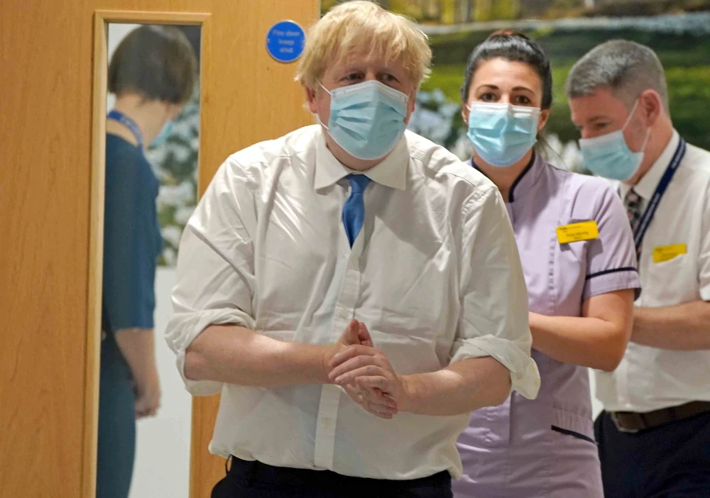 Prime Minister Boris Johnson, center, arrives to visit to the Northern Centre for Cancer Care, North Cumbria, in Carlisle, as part of his tour of Britain, Monday Feb. 14, 2022. (AP)