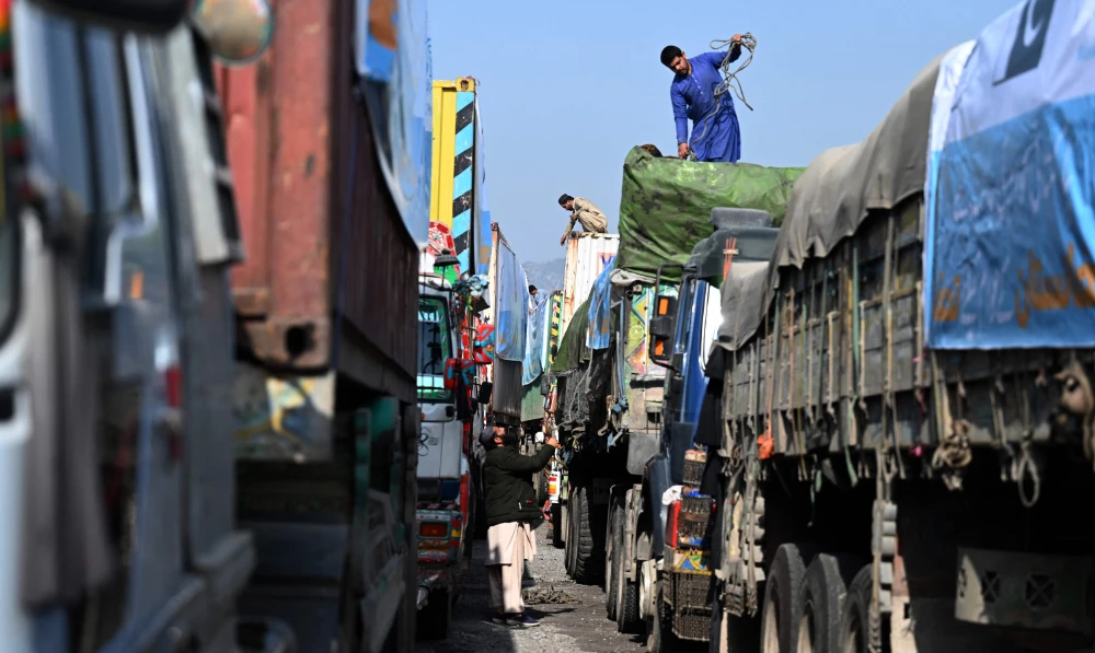 Truckers prepare for their departure to Afghanistan carrying containers loaded with food and other relief items for the Afghan people in Islamabad. (AFP)