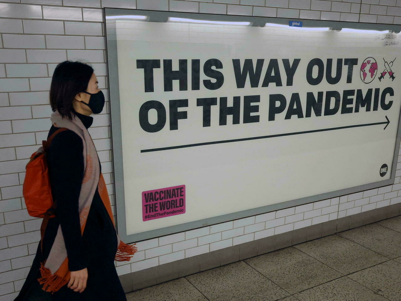 A woman walks past a sign amidst the spread of the coronavirus disease (COVID-19), London, Britain, Jan. 24, 2022. (Reuters)