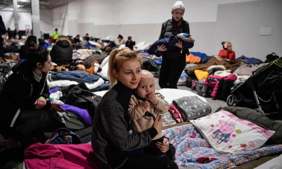 A mother and child await relocation from a temporary shelter for Ukrainian refugees in Przemysl, southeastern Poland. (AFP)