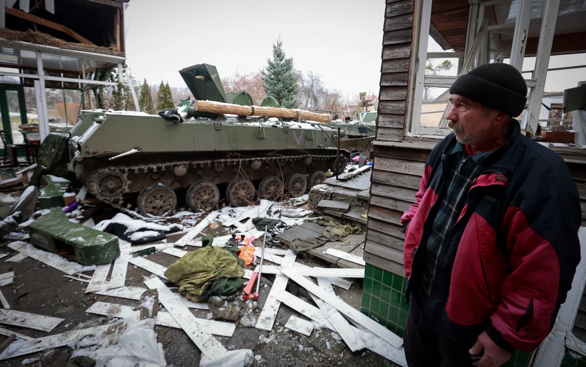 A man looks at the gutted remains of Russian military vehicles on a road in the town of Bucha, close to the capital Kyiv, Ukraine, Tuesday, March 1, 2022. (AP)