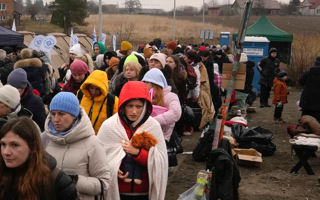 A young woman clutches a doll, after fleeing Ukraine, at the border crossing in Medyka, Poland, Saturday, March 5, 2022. (AP)