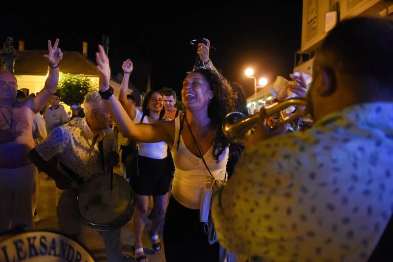 Women enjoy music during the annual brass band festival in Guca, Serbia, Aug. 13, 2021. (Reuters)