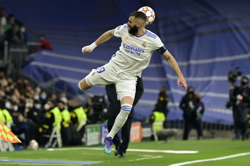 Real Madrid's French forward Karim Benzema heads the ball during the UEFA Champions League round of 16 second league football match between Real Madrid CF and Paris Saint-Germain at the Santiago Bernabeu stadium in Madrid on March 9, 2022. (AFP)