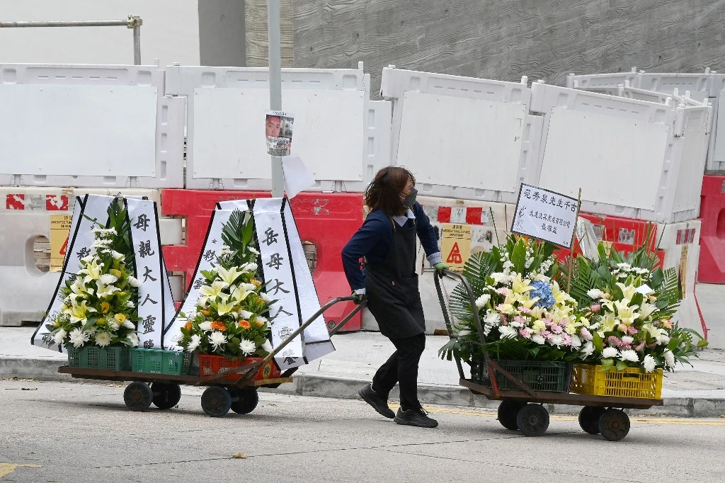 Above, a woman transfers wreaths at the Fu Shan Public Mortuary in Hong Kong on Mar. 6, 2022. (AFP)