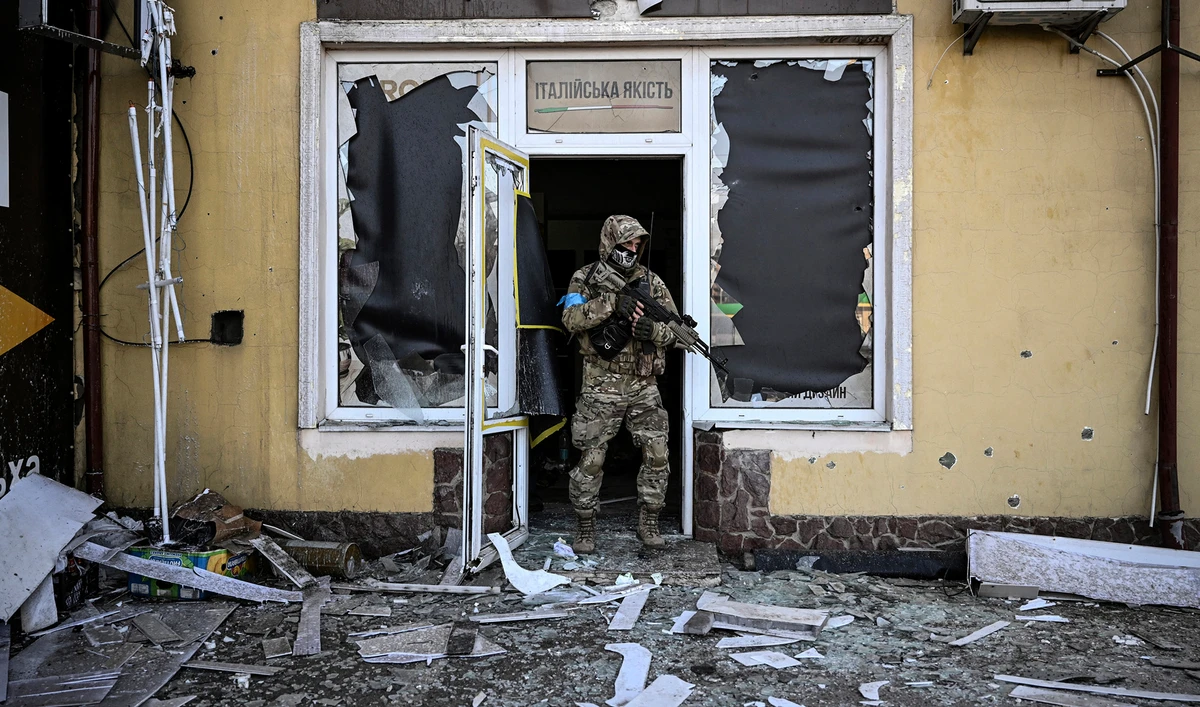 A Ukrainian serviceman exits a damaged building after shelling in Kyiv, on March 12, 2022. (AFP)