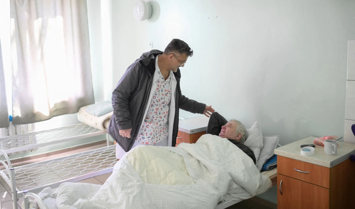 Syrian doctor Ossama Jari (L) tends to a patient at a hospital in Mykolaiv, on March 12, 2022. (AFP)