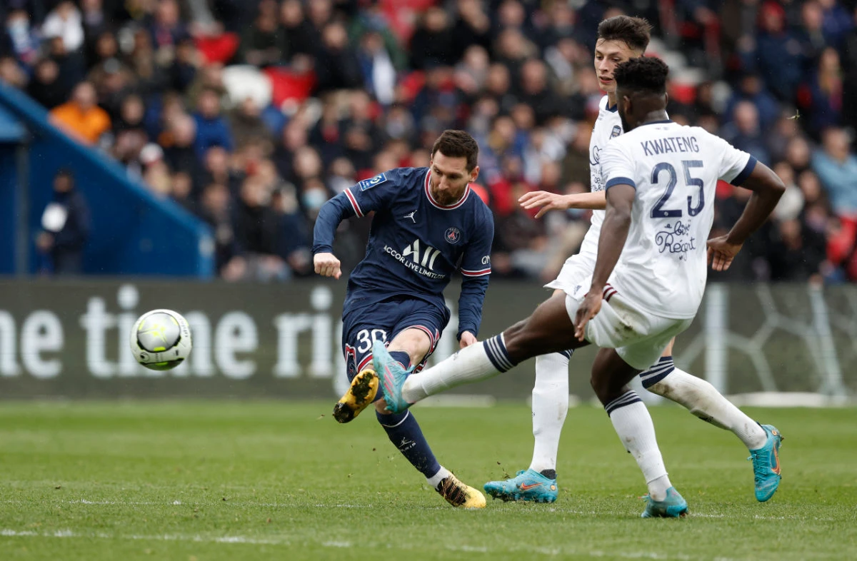 Paris St Germain's Lionel Messi shoots at goal as Bordeaux's Enock Kwateng attempts to block during their match on March 13, 2022. (REUTERS/Benoit Tessier)