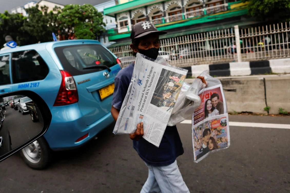 A street vendor sells papers with the news of Indonesian New Capital Nusantara on its headline in Jakarta on Mar. 15, 2022. (Reuters)
