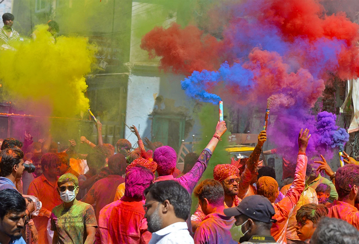 Revellers smeared in coloured powder dance during the Holi celebrations in Hyderabad, India, on March 17, 2022. (AFP)