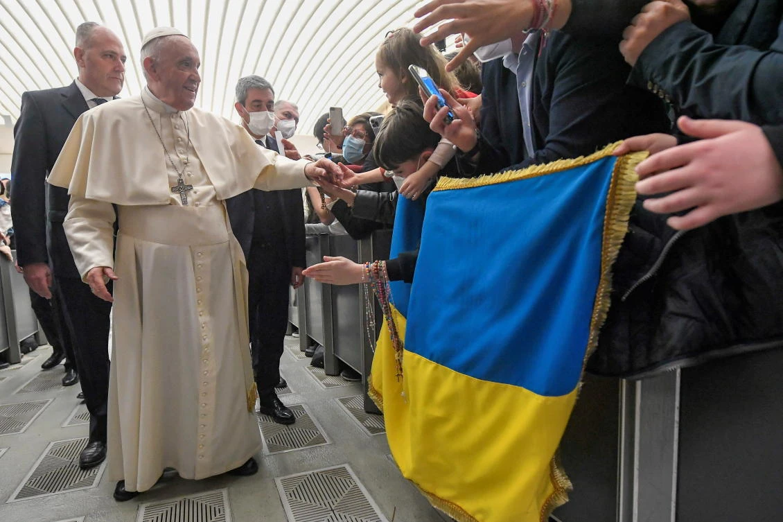 Pope Francis greets people who hold Ukrainian flag, amid ongoing Russia’s invasion of Ukraine, at the weekly general audience at the Paul VI Hall at the Vatican on Wednesday. (Reuters)