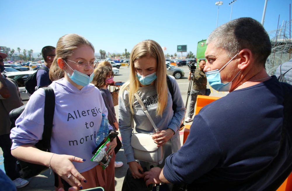 A Ukrainian family chat as they seek for a humanitarian visa at the San Ysidro Port of Entry of the U.S.-Mexico border in Tijuana, Mexico March 15, 2022. Picture taken March 15, 2022. (REUTERS)
