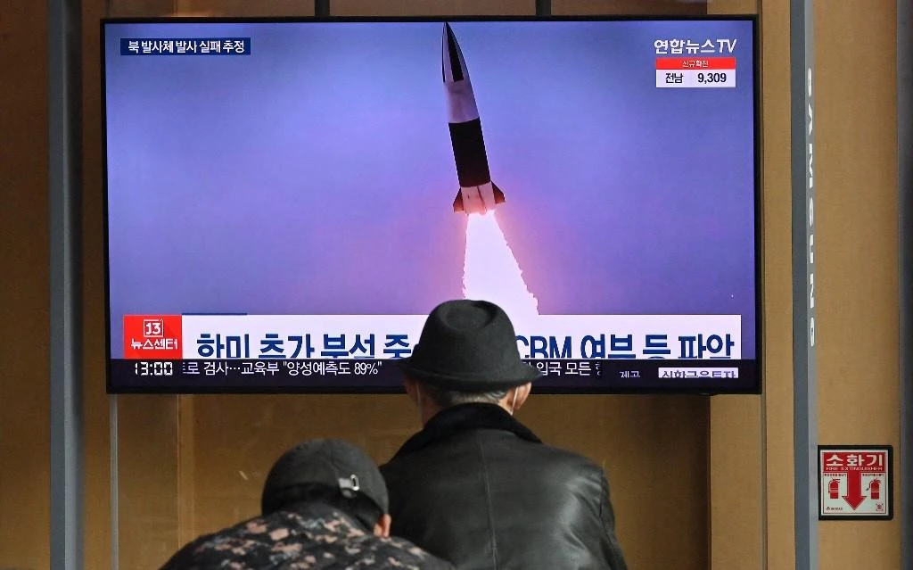 Above, file footage of a North Korean missile test is shown on a news broadcast at a railway station in Seoul on March 16, 2022. (AFP)
