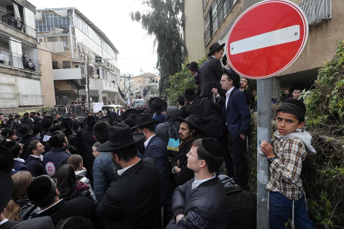 Ultra-Orthodox Jewish men and children gather outside the home of late rabbi Chaim Kanievsky, ahead of his funeral in the Israeli city of Bnei Brak near Tel Aviv, on March 20, 2022. (AFP)