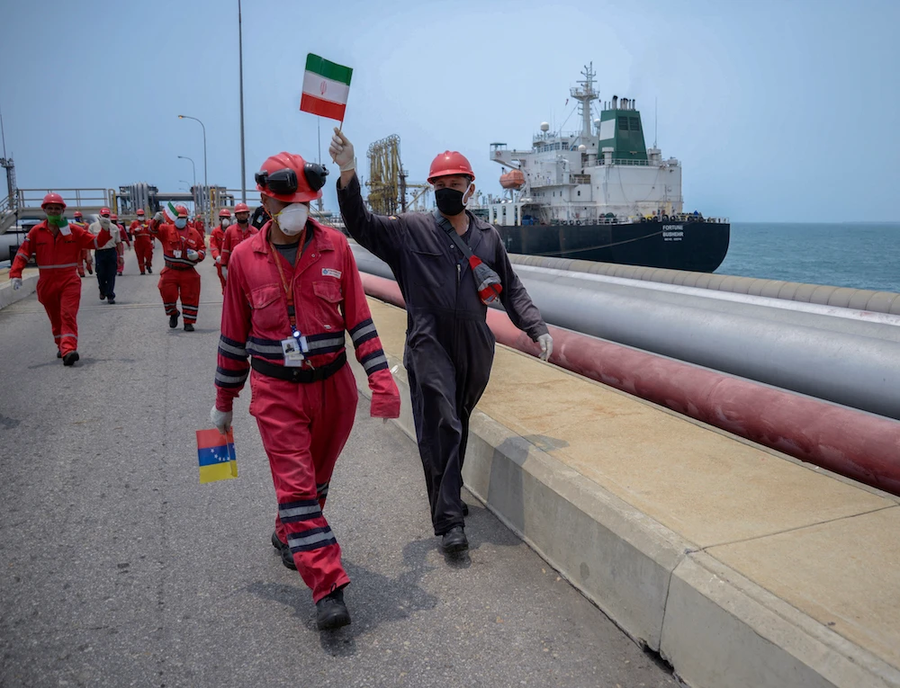 A Venezuelan oil worker waves an Iranian flag, a symbol of the growing relationship between the two countries. (AFP/File Photo)