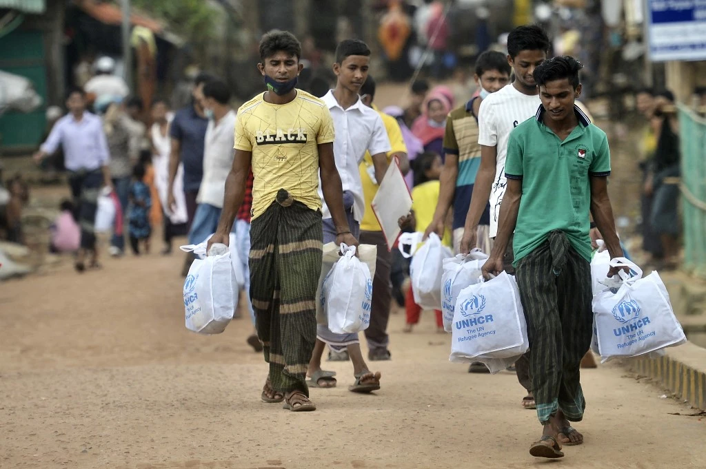 Rohingya refugees walk back home after collecting relief material at Kutupalong refugee camp in Ukhia, Bangladesh. (File/AFP)