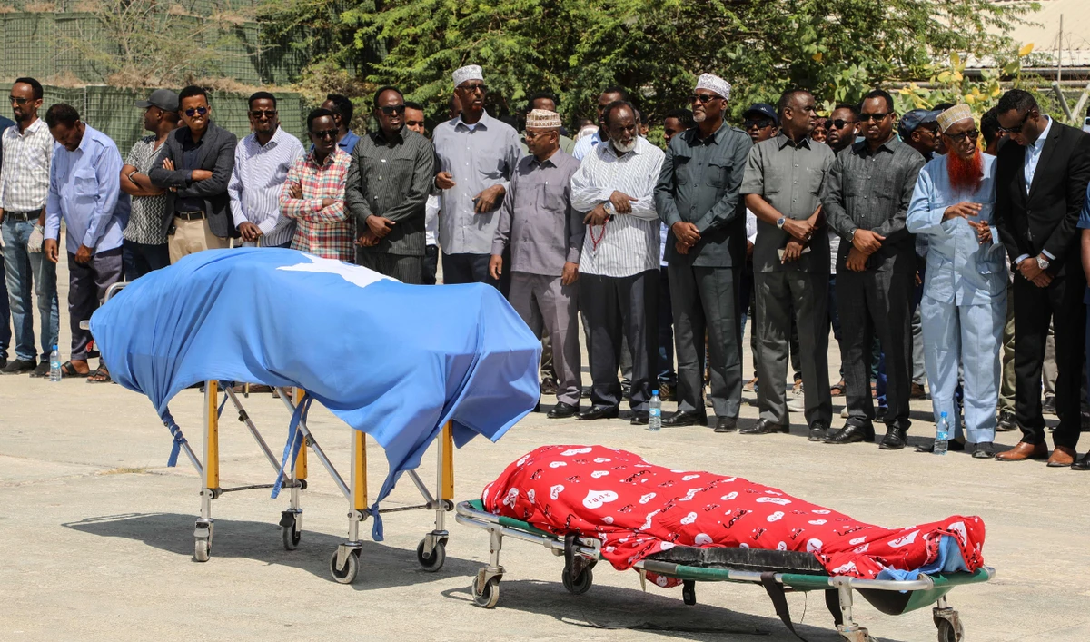 Political leaders pray in front the two bodies of the local lawmakers including Amina Mohamed Abdi after being airlifted from Beledweyne, at Aden Adde International Airport in Mogadishu, Somalia, on March 24, 2022. (AFP)