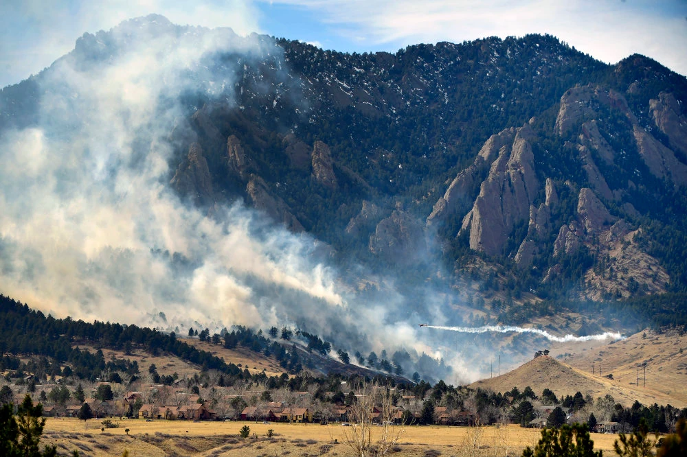 A single engine air tanker drops water on the NCAR fire as it burns in the foothills south of the National Center for Atmospheric Research Saturday, March 26, 2022 in Boulder, Colo. (AP)