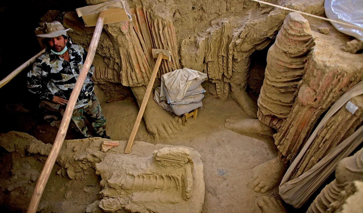 An Afghan archeologist stands next to remains of Buddha statues discovered inside an ancient temple in Mes Aynak valley, south of Kabul, Afghanistan on October 12, 2010. (AP/File)