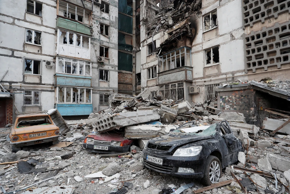 Destroyed cars are seen in front of an apartment building which was heavily damaged during Ukraine-Russia conflict in Mariupol, Ukraine March 27, 2022. (Reuters)
