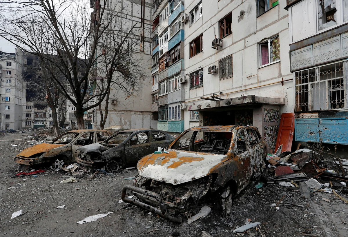 Destroyed cars are seen in front of an apartment building which was damaged during Ukraine-Russia conflict in the besieged southern port city of Mariupol, Ukraine March 27, 2022. (Reuters)