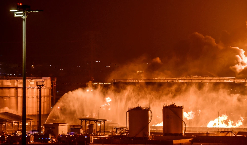 Water is sprayed by fire brigades toward the smoke and flames rising from a Saudi Aramco oil facility in Jeddah following a reported Yemeni rebels attack. (AFP file photo)